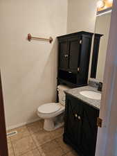 Bathroom featuring tile patterned flooring, vanity, and toilet