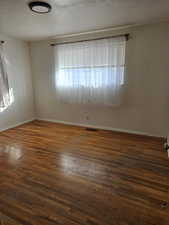 Spare room with dark hardwood / wood-style floors