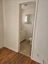 Bathroom featuring hardwood / wood-style floors, vanity, and toilet