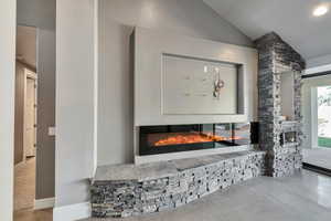 Room details featuring a fireplace and concrete floors