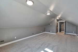 Bonus room featuring carpet flooring and vaulted ceiling