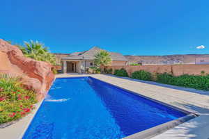 View of swimming pool featuring pool water feature and a patio