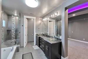 Bathroom featuring vanity, tile patterned floors, a textured ceiling, and plus walk in shower