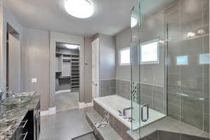 Bathroom featuring vanity, a textured ceiling, separate shower and tub, and tile patterned flooring