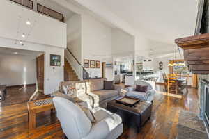 Living room featuring high vaulted ceiling, a fireplace, and dark hardwood / wood-style flooring