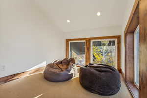 Sitting room featuring lofted ceiling and carpet flooring