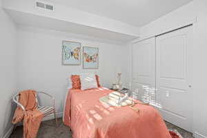 Carpeted bedroom featuring a closet