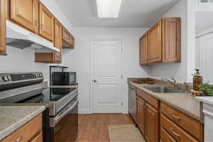 Kitchen with appliances with stainless steel finishes, sink, and light wood-type flooring