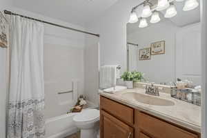 Full bathroom with vanity, toilet, tile patterned floors, and shower / bathtub combination with curtain