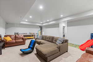 Carpeted living room featuring a raised ceiling