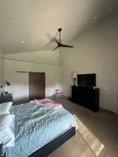 Bedroom with ceiling fan, carpet, vaulted ceiling, and a barn door