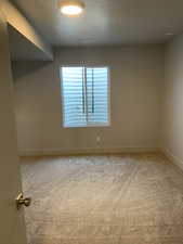 Spare room with a textured ceiling and carpet floors