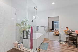 Bathroom featuring separate shower and tub and wood-type flooring