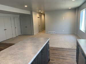 Kitchen with stainless steel dishwasher, light hardwood / wood-style flooring, and a textured ceiling