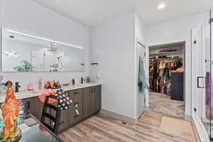 Bathroom featuring hardwood / wood-style floors, vanity, and a shower with shower door