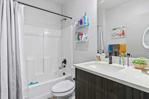 Full bathroom featuring vanity, toilet, and shower / tub combo with curtain