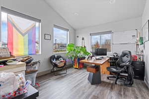 Office space with wood-type flooring, vaulted ceiling, and plenty of natural light