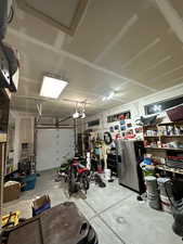 Garage with a garage door opener and stainless steel fridge with ice dispenser