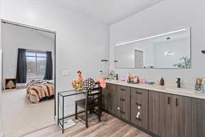 Bathroom with hardwood / wood-style flooring, vanity, and lofted ceiling