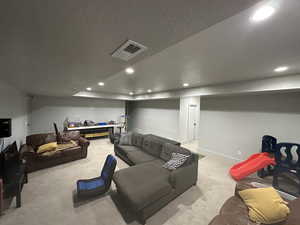 Carpeted living room with a textured ceiling