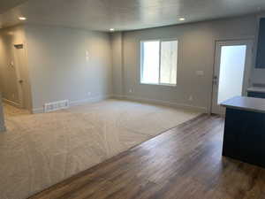 Interior space with a textured ceiling and hardwood / wood-style flooring