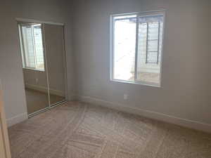 Unfurnished bedroom featuring a closet and carpet floors