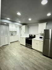 2nd Kitchen featuring appliances with stainless steel finishes, white cabinets, and LVP flooring in basement