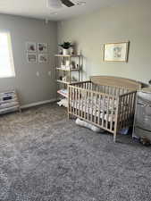 4th bedroom with a nursery area and ceiling fan