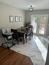 Dining room featuring a chandelier, french doors, a textured ceiling, and LVP floors