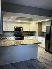 Kitchen with sink, white cabinets, stainless steel appliances, and recessed lighting