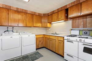 Clothes washing area with sink and washer and dryer