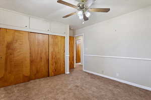 Bedroom featuring a closet, light colored carpet, and ceiling fan