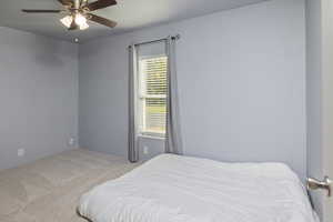 Bedroom with light colored carpet and ceiling fan