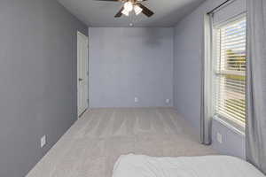 Carpeted bedroom featuring ceiling fan