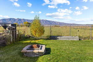 View of yard featuring a mountain view, an outdoor fire pit, and a rural view