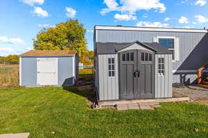 View of outdoor structure with a yard