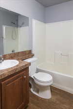 Full bathroom featuring toilet, hardwood / wood-style floors, vanity, and  shower combination