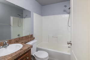 Full bathroom featuring toilet, vanity, and bathing tub / shower combination