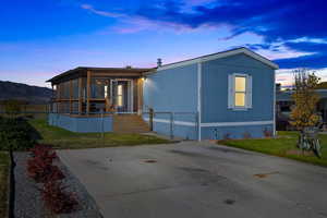 Manufactured / mobile home featuring a lawn and a sunroom