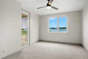 Carpeted spare room featuring baseboards and a ceiling fan