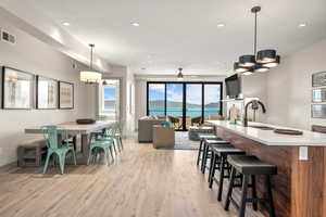 Dining area featuring a chandelier, light wood-style floors, baseboards, recessed lighting, and a ceiling fan