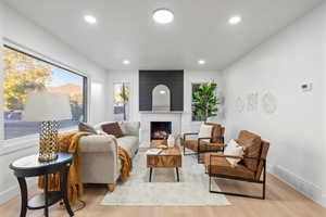 Living room with light hardwood / wood-style floors and a fireplace