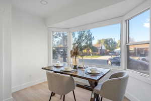 Dining space featuring light wood-type flooring & bay window