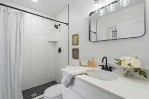 Bathroom featuring vanity, toilet, and a shower with shower curtain