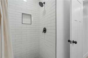 Bathroom featuring a tile shower with shower