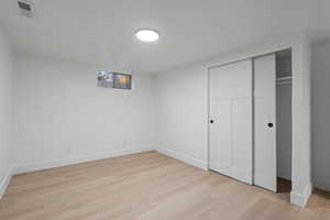 Unfurnished bedroom with light hardwood / wood-style flooring and a closet