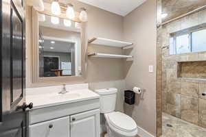 ADU Bathroom featuring vanity, toilet, and tiled shower