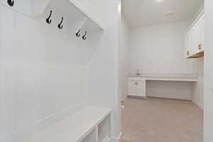 Mudroom with light tile patterned flooring and sink