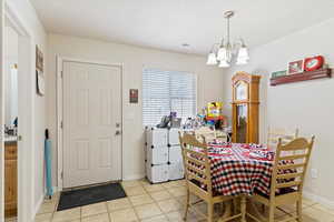 Dining room featuring light tile patterned floors and a chandelier