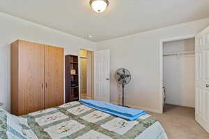 Carpeted bedroom with two closets and a textured ceiling